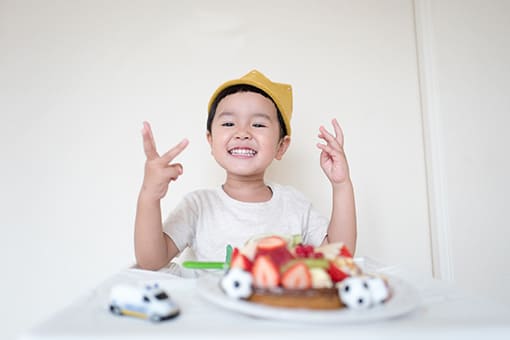 enfant riant devant un gâteau aux fraises - page d’accueil de Bambinou - encart d’abonnement à la newsletter de Bambinou